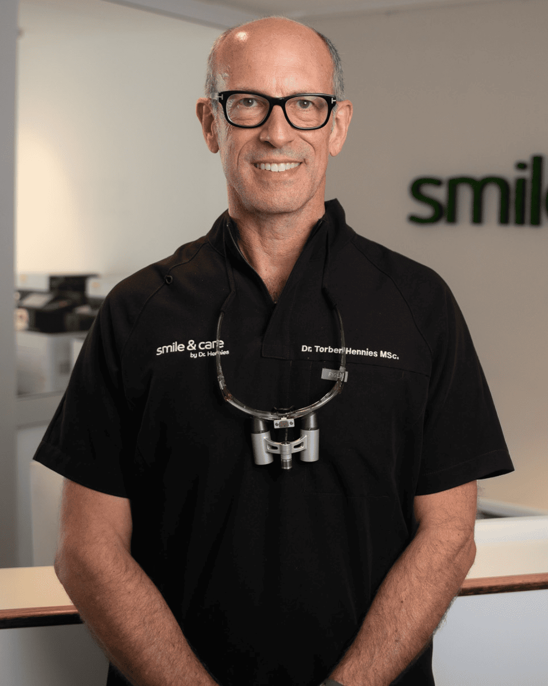 Dr. Hennies in schwarzer Praxiskleidung in den modernen Praxisräumen von smile & care in Göttingen.